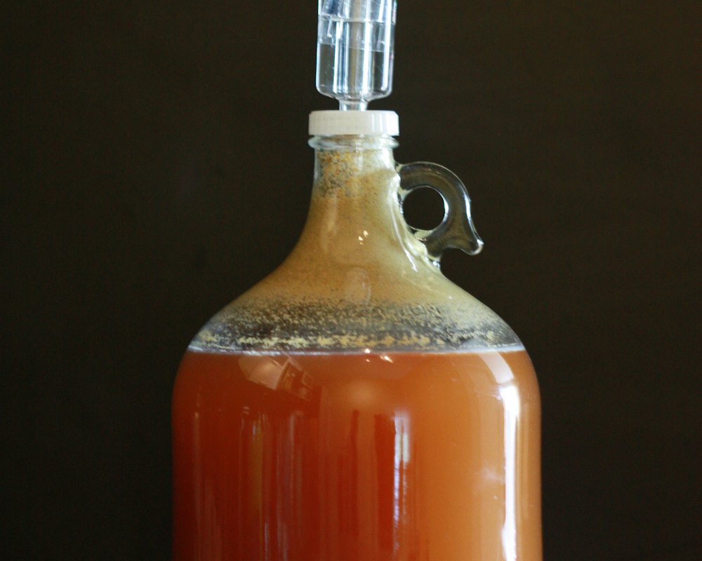 Jugs of fresh apple cider on a wooden table
